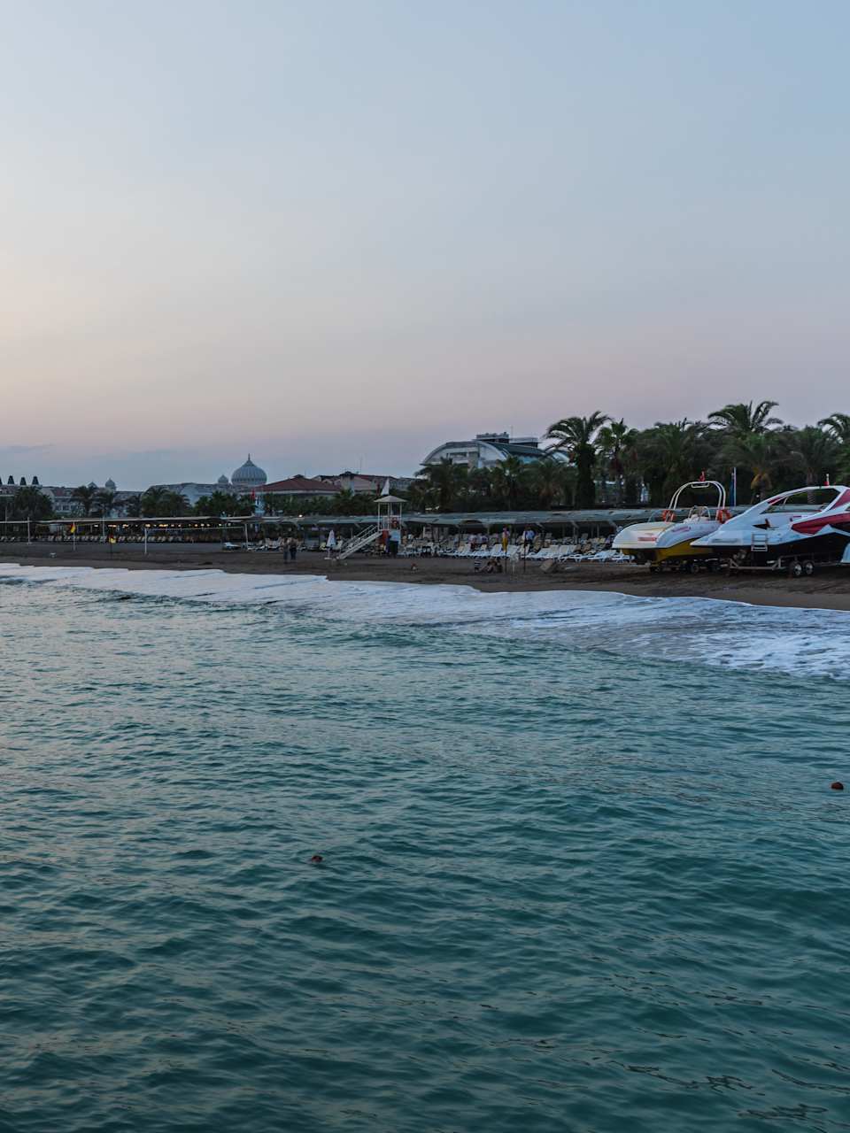 Ein Strand mit Booten und Gebäuden im Hintergrund